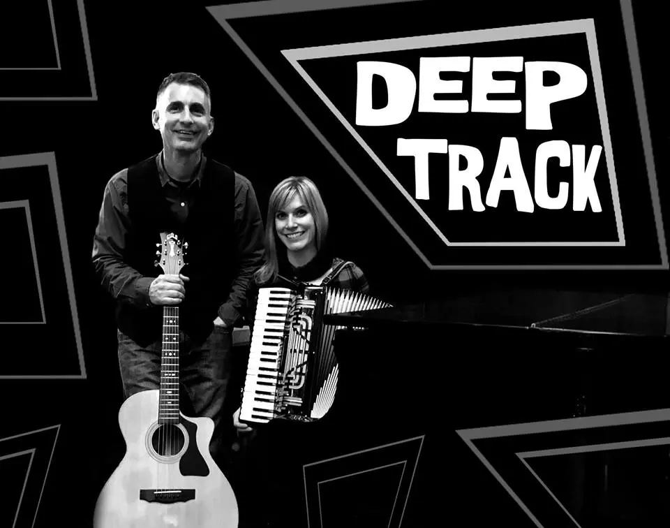 A man and woman standing in front of an accordion with the words deep track.