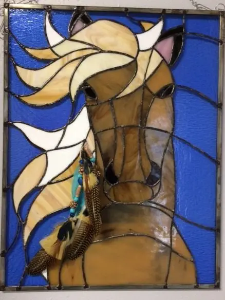 A stained glass panel with a horse on it.