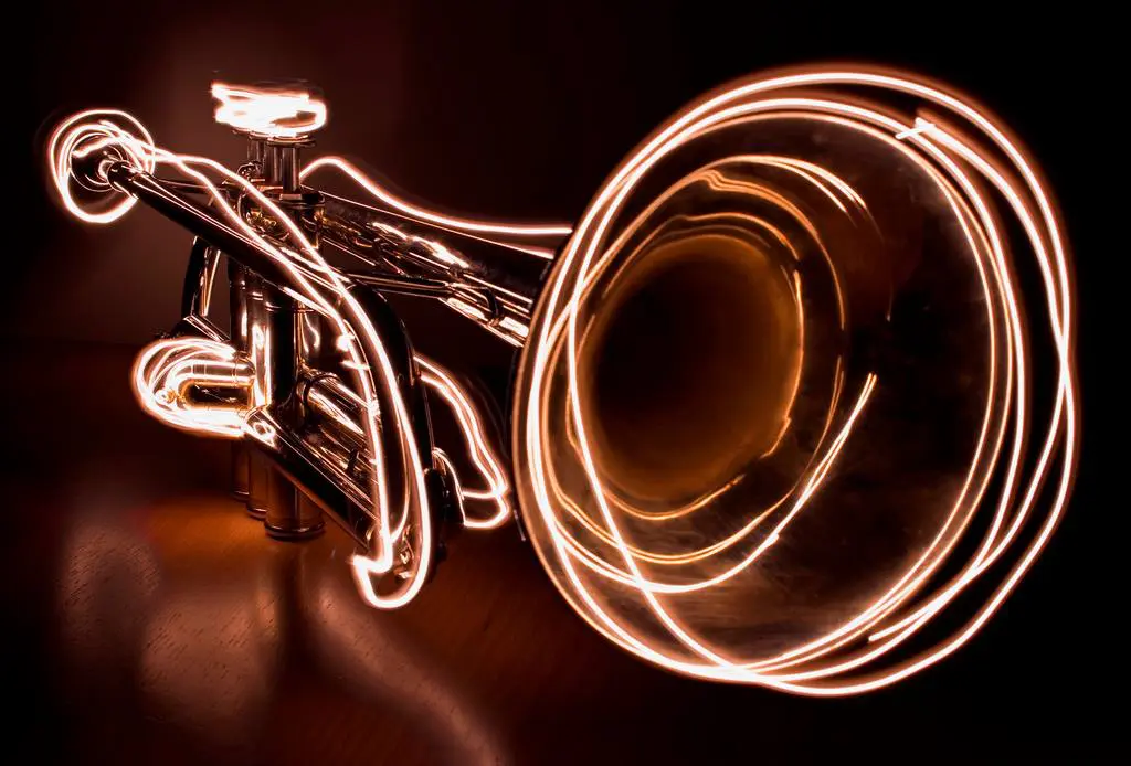 A light drawing of a trumpet on a black background.