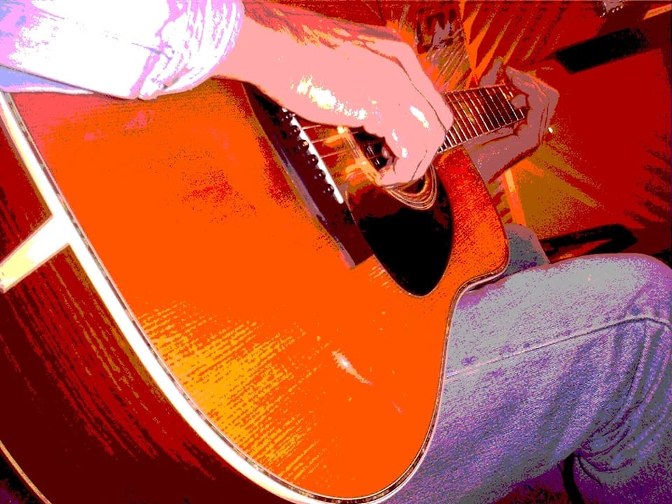 A person playing an acoustic guitar.