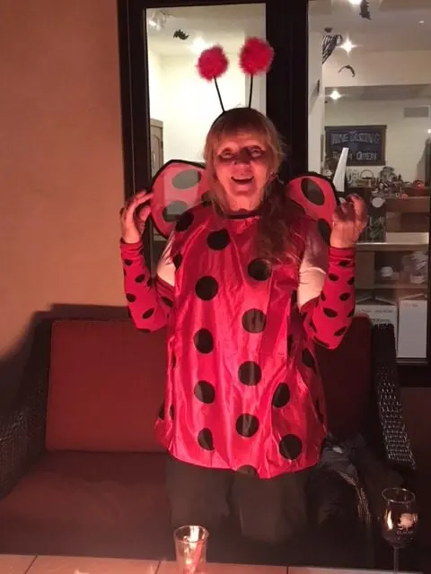 A woman dressed up as a lady bug at a restaurant.
