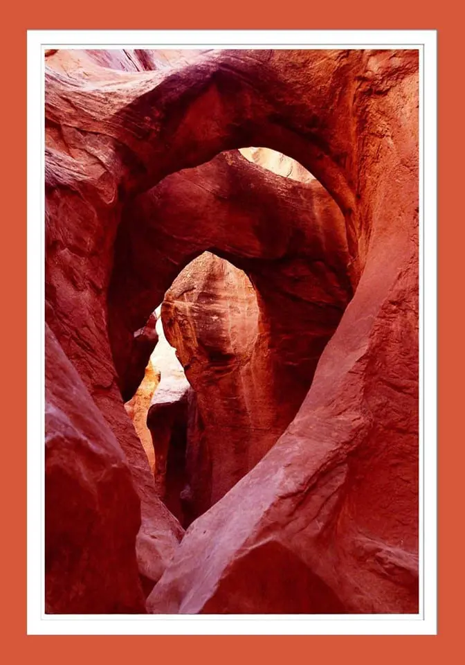 A picture of a red rock arch in a canyon.