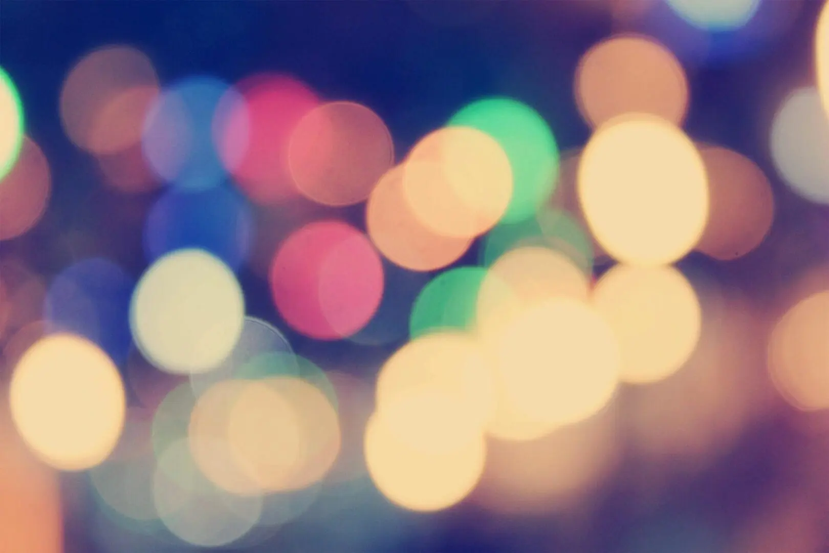 A blurry image of bokeh lights on a dark background.