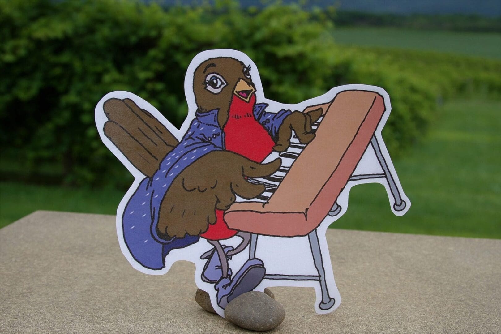A paper cut out of a robin playing a piano.