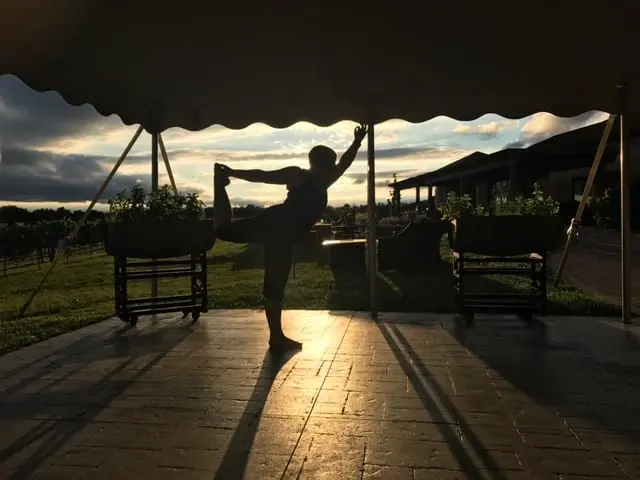 A woman doing yoga in a tent at sunset.