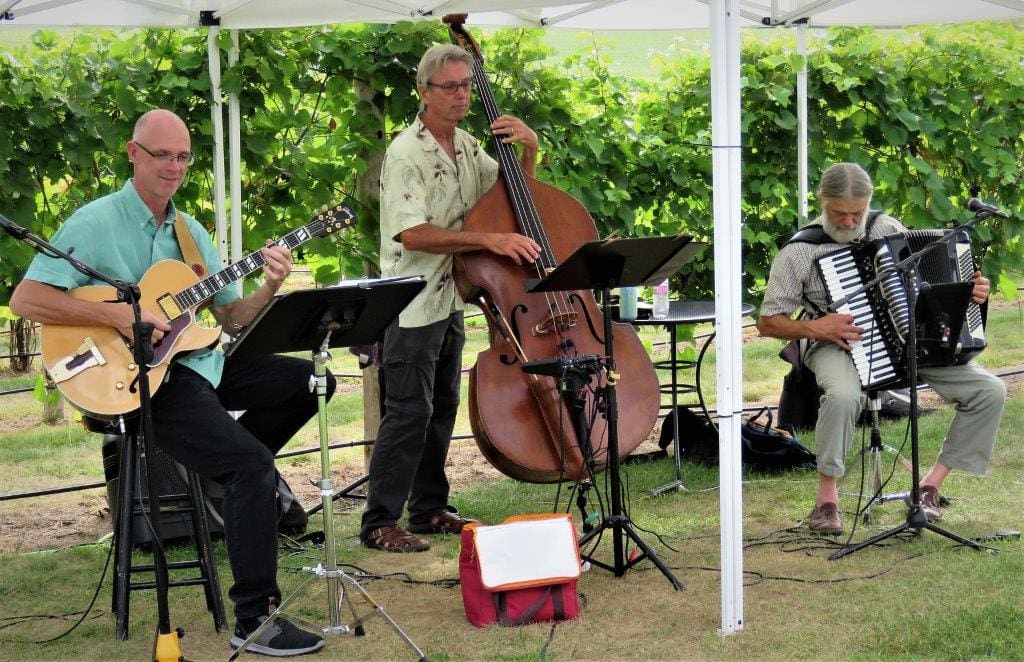 A group of men playing music under a tent.