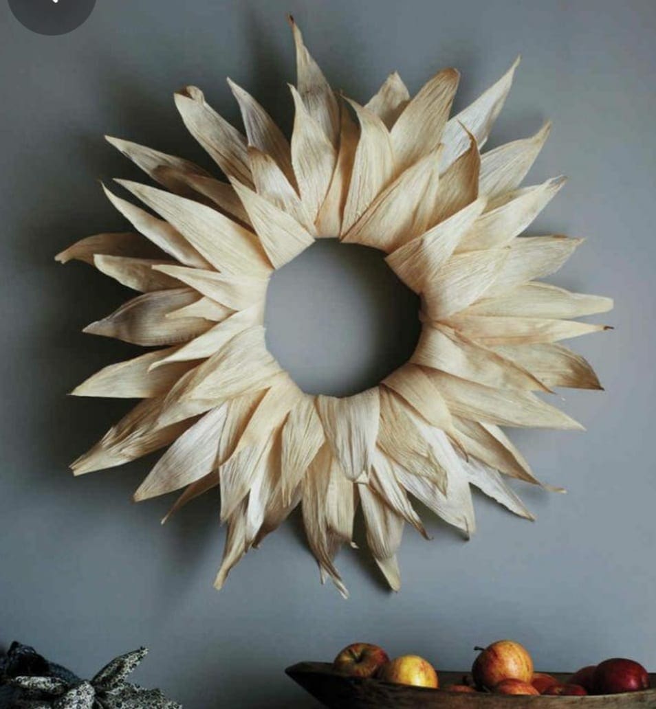 A sunflower wreath is hanging on a wall.