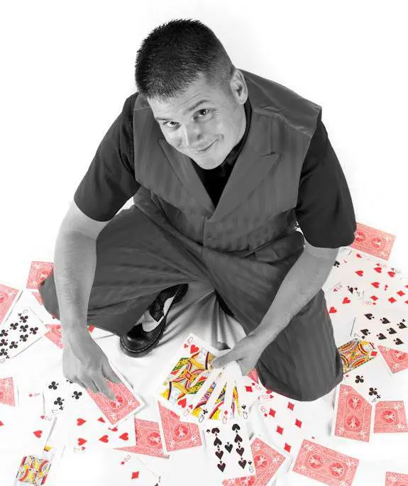 A man sitting on a pile of playing cards.