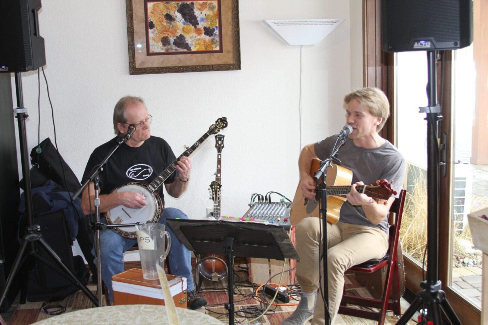 Two men playing music in a living room.