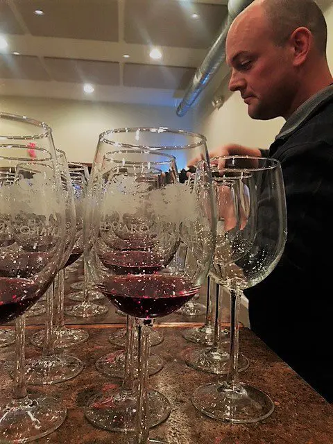 A man pouring wine into wine glasses.