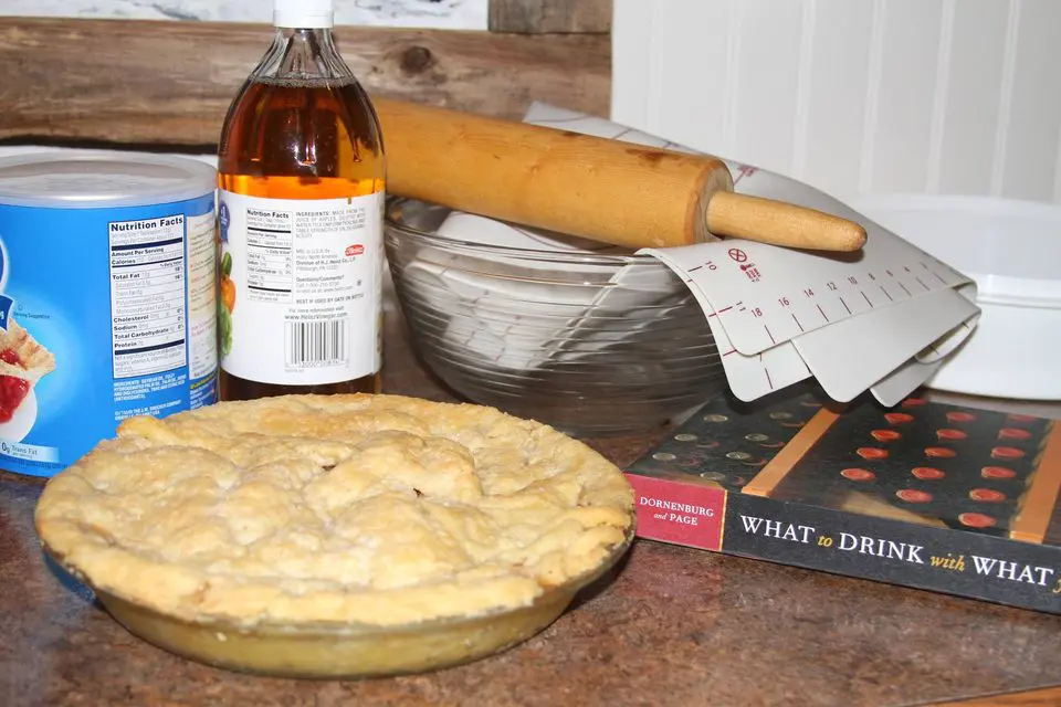 The ingredients for an apple pie are sitting on a counter.