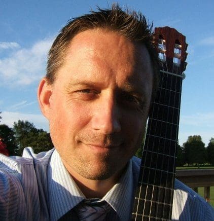 A headshot of a man with his guitar