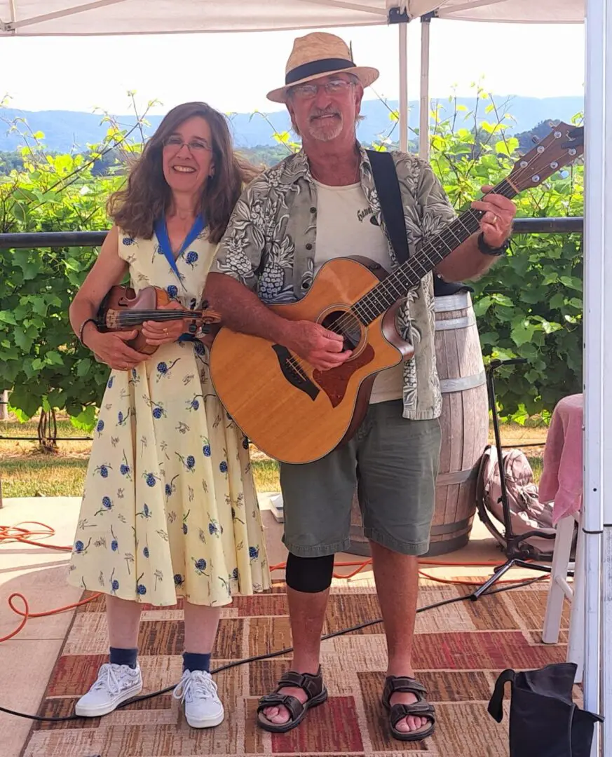 A man and woman playing music outdoors.